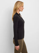 Black ribbed long-sleeve polo with a collar and button placket.