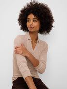 Light beige ribbed knit polo shirt with a collar, long sleeves, and a button-front V-neck opening.