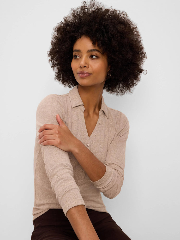Light beige ribbed knit polo shirt with a collar, long sleeves, and a button-front V-neck opening.