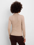 Back view of a person wearing a light beige, ribbed, long-sleeved polo.