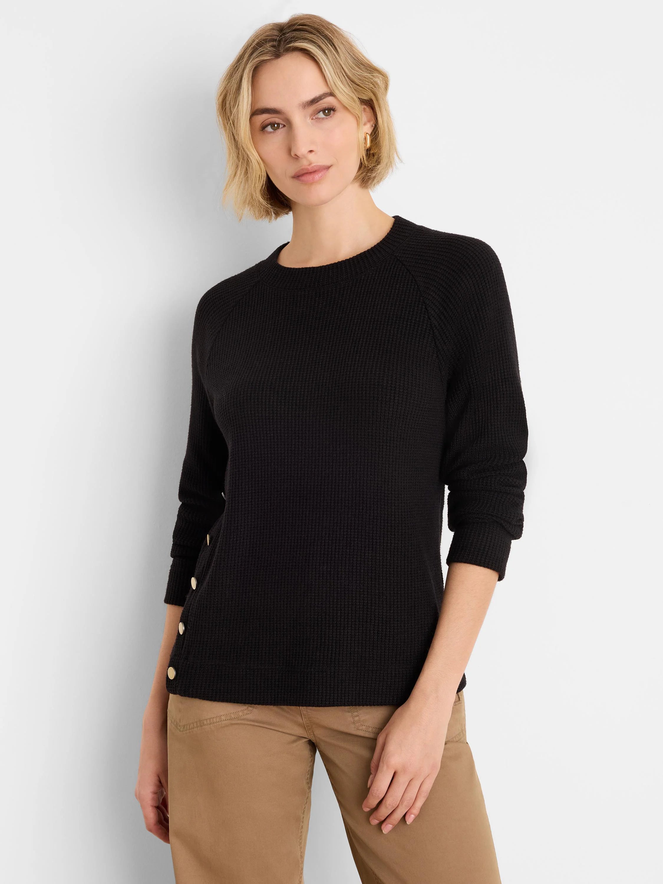 Black waffle knit top with gold side buttons, crew neck, and long sleeves.