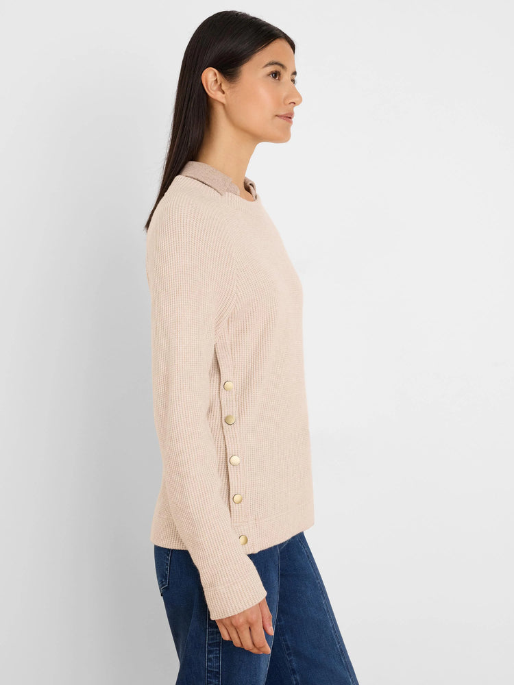 Light beige waffle knit top with a crew neck, long sleeves, and five round gold buttons down the left side.