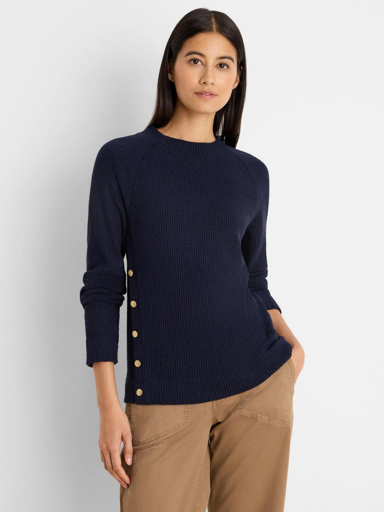 Navy ribbed top with long sleeves, crew neck, and gold buttons vertically on the left side.