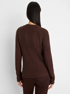 Brown waffle knit top with long sleeves on a model, back view.