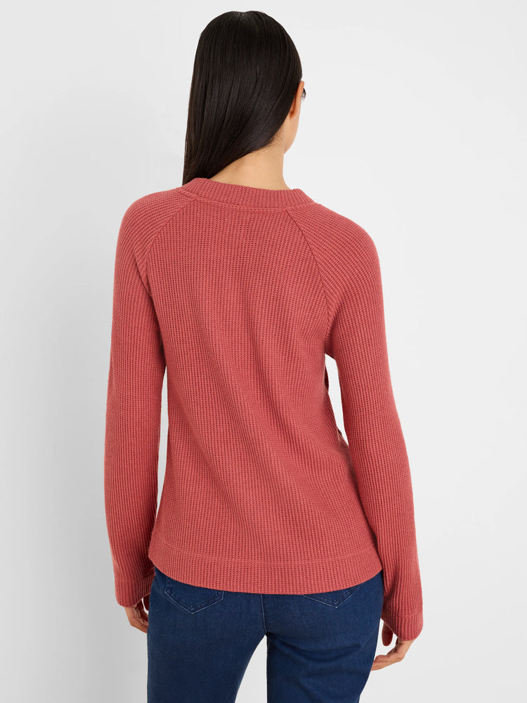 Rust waffle knit top with long raglan sleeves and round neck, shown from the back.