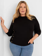 Black waffle knit top with 3/4 sleeves, mock neck, and decorative gold buttons down the left side.