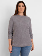 Grey waffle knit top with a crew neck, long sleeves, and brass buttons running down one side.