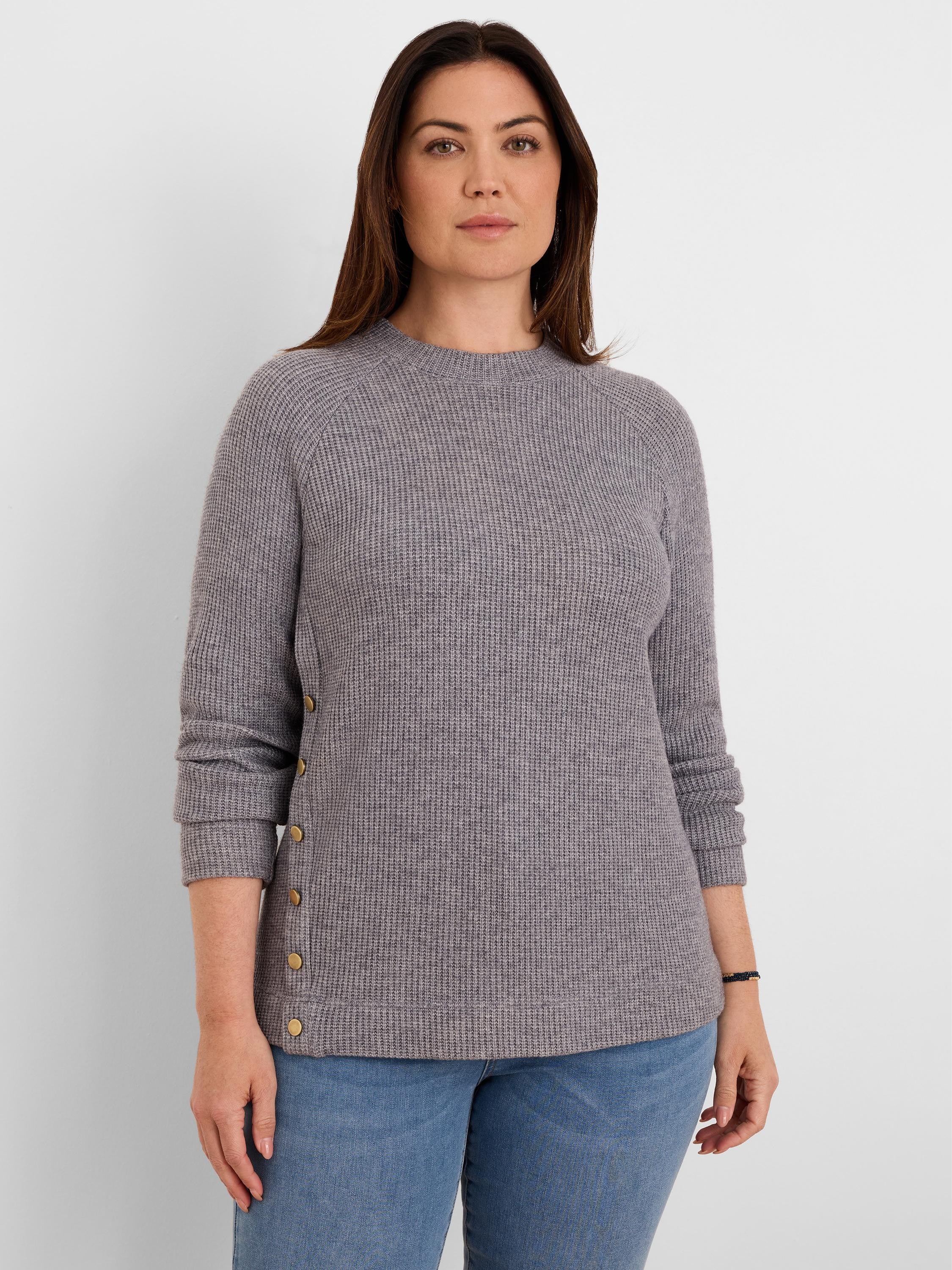 Grey waffle knit top with a crew neck, long sleeves, and brass buttons running down one side.