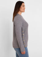 Grey waffle knit long-sleeve top with gold buttons down the left side seam.
