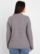 Back of a model wearing a mottled grey waffle knit top. Features long raglan sleeves and a relaxed fit.