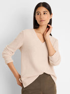 Pale beige waffle knit thermal top with a V-neck and long sleeves.