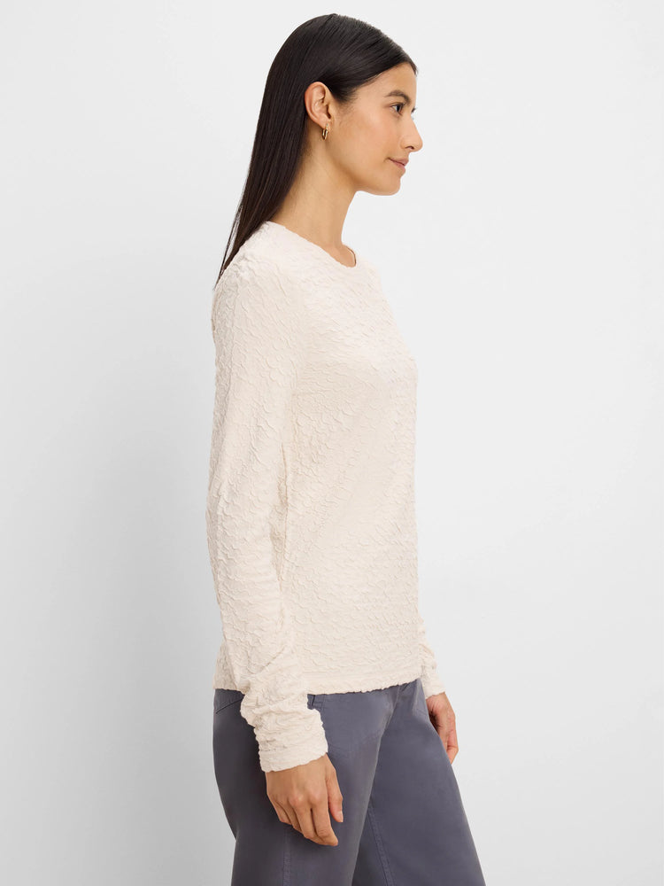 Pale cream long-sleeve top with crinkle knit texture.