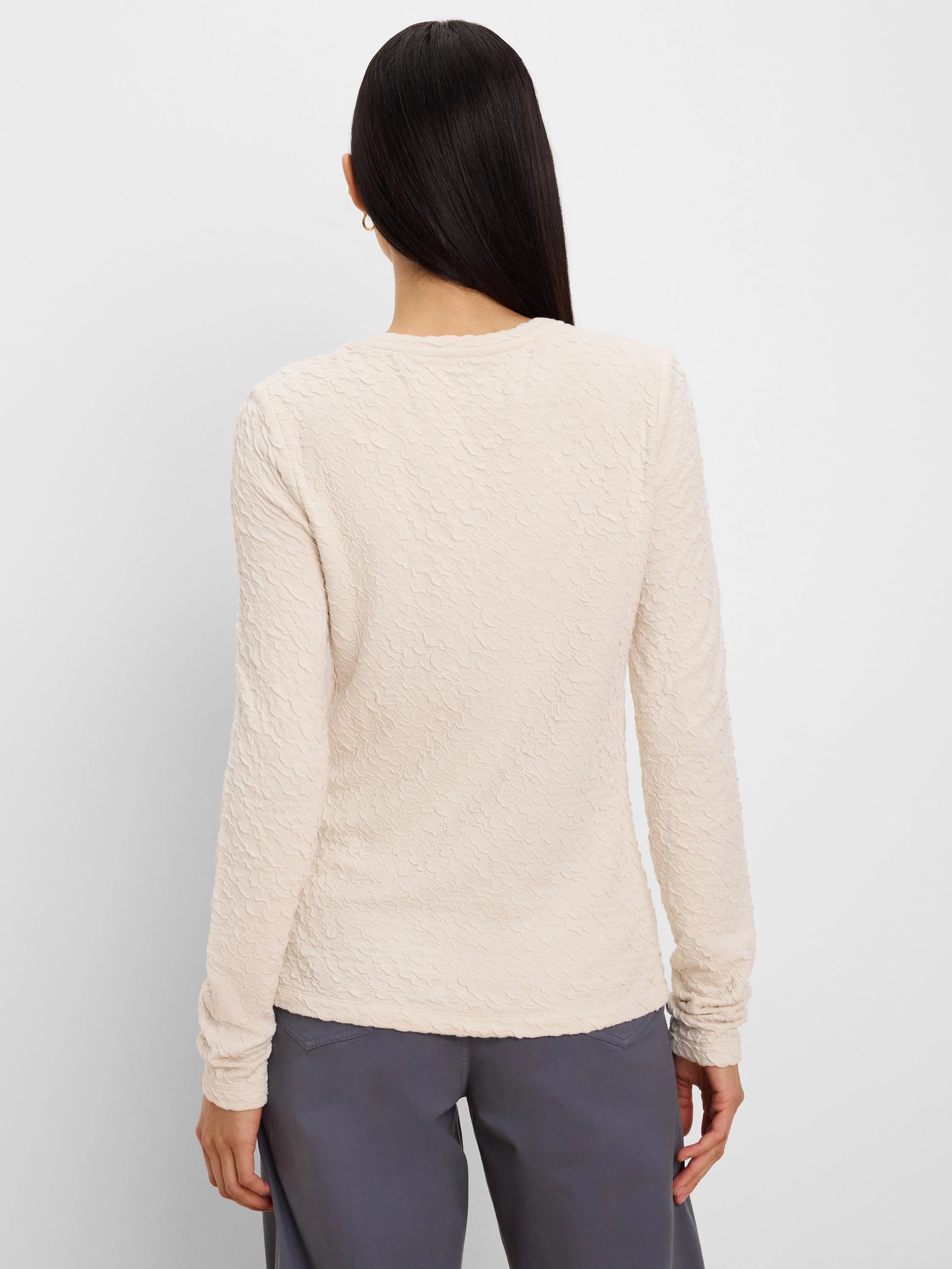 Cream crinkle knit long-sleeve top, all-over wavy texture, back view on model.