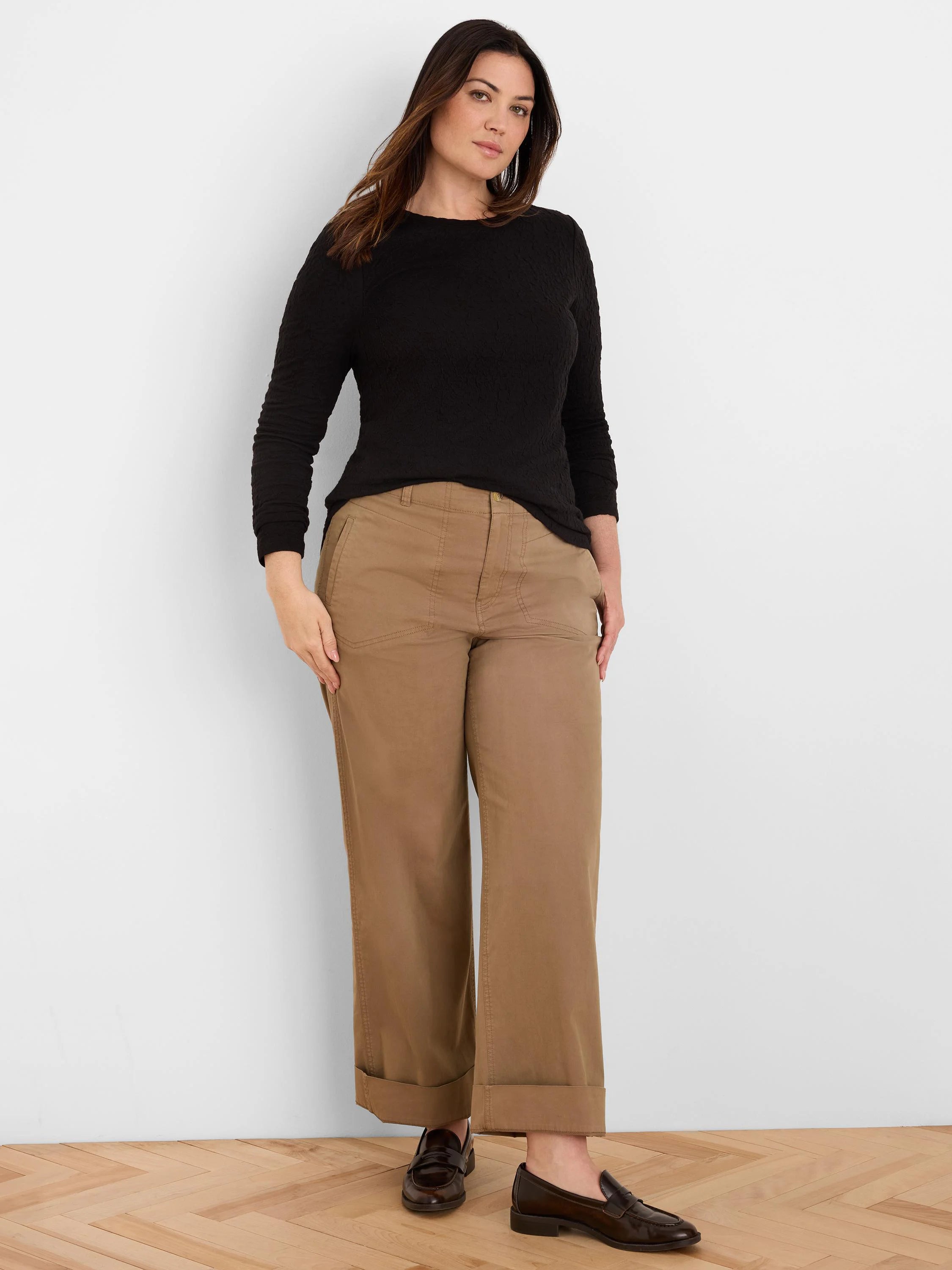 Black long-sleeved top with subtle crinkle knit texture, worn by a model.