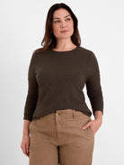 Dark brown crinkle knit top with an all-over puckered texture, 3/4 sleeves, and a round neckline.