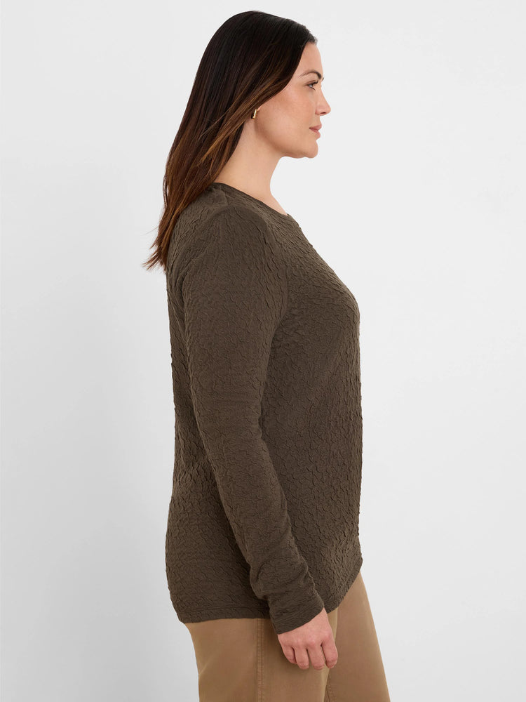 Dark olive green long-sleeve top with an all-over crinkle knit texture, worn by a model.