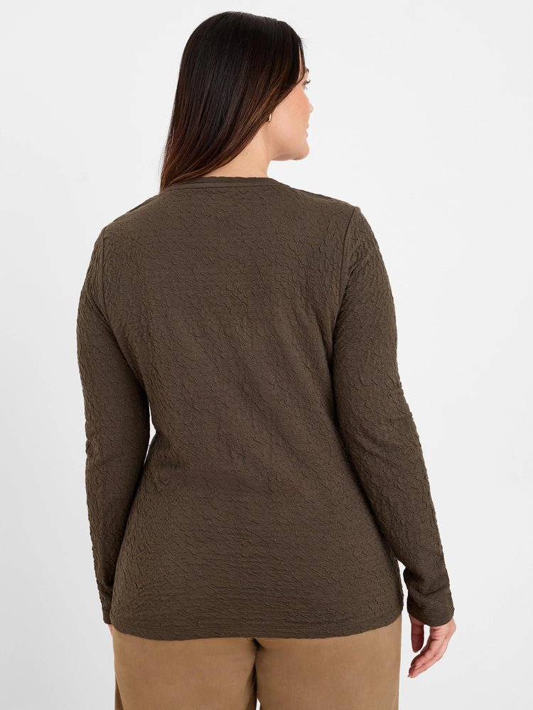 Dark olive green crinkle knit long-sleeve top on model, back view.