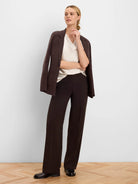 Dark brown knit blazer. Relaxed fit, soft texture, with front patch pockets. Draped over shoulders.