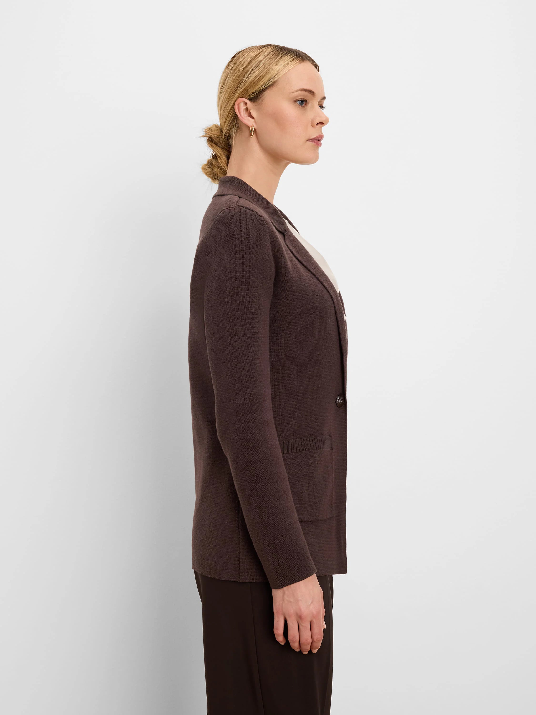 Dark brown knit blazer with notched lapels, a single button, and a patch pocket, shown on a model.
