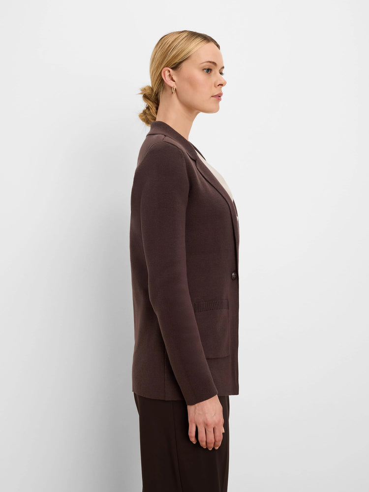 Dark brown knit blazer with notched lapels, a single button, and a patch pocket, shown on a model.