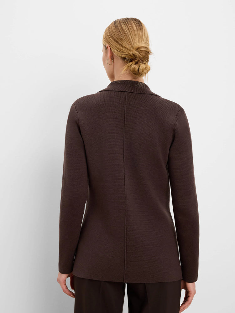Dark brown knit blazer with a collar and center back seam, worn by a woman facing away.