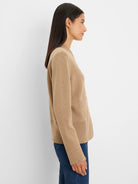 Tan knit bomber jacket with ribbed cuffs, hem, side pockets, and a snap front, shown on a model.