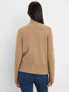 Back view of a tan knit bomber jacket with a ribbed mock neck and hem.