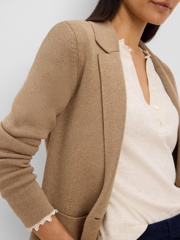 Camel knit tailored blazer with lapels and visible knit texture, worn over a cream shirt.