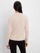 Light beige knit blazer, back view. Shows tailored collar and vertical back seam.