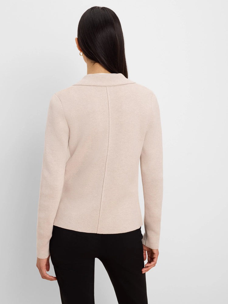 Light beige knit blazer, back view. Shows tailored collar and vertical back seam.