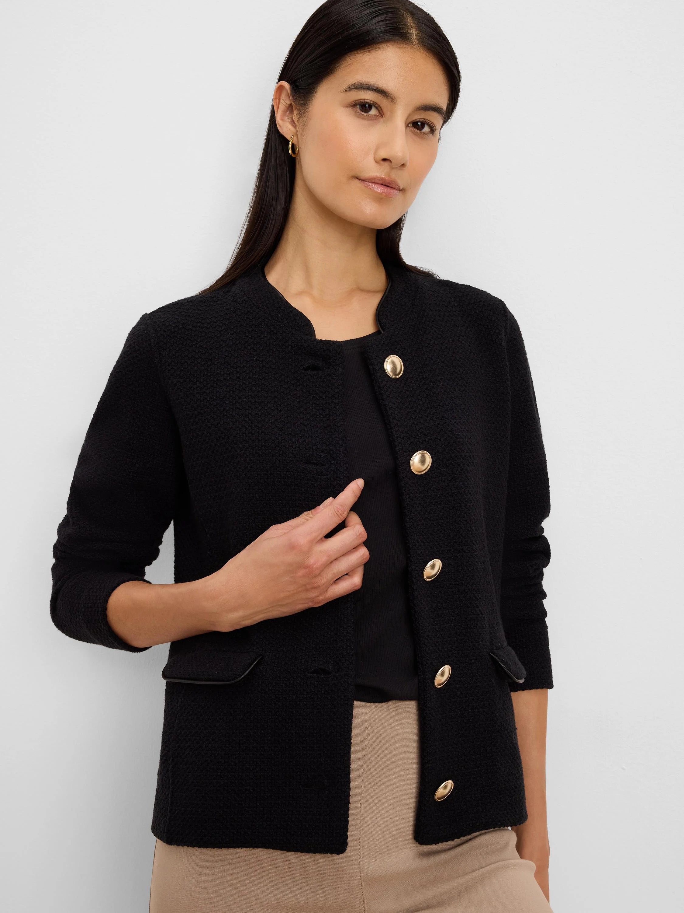 Black textured knit jacket, collarless, with gold buttons and black trimmed pockets.