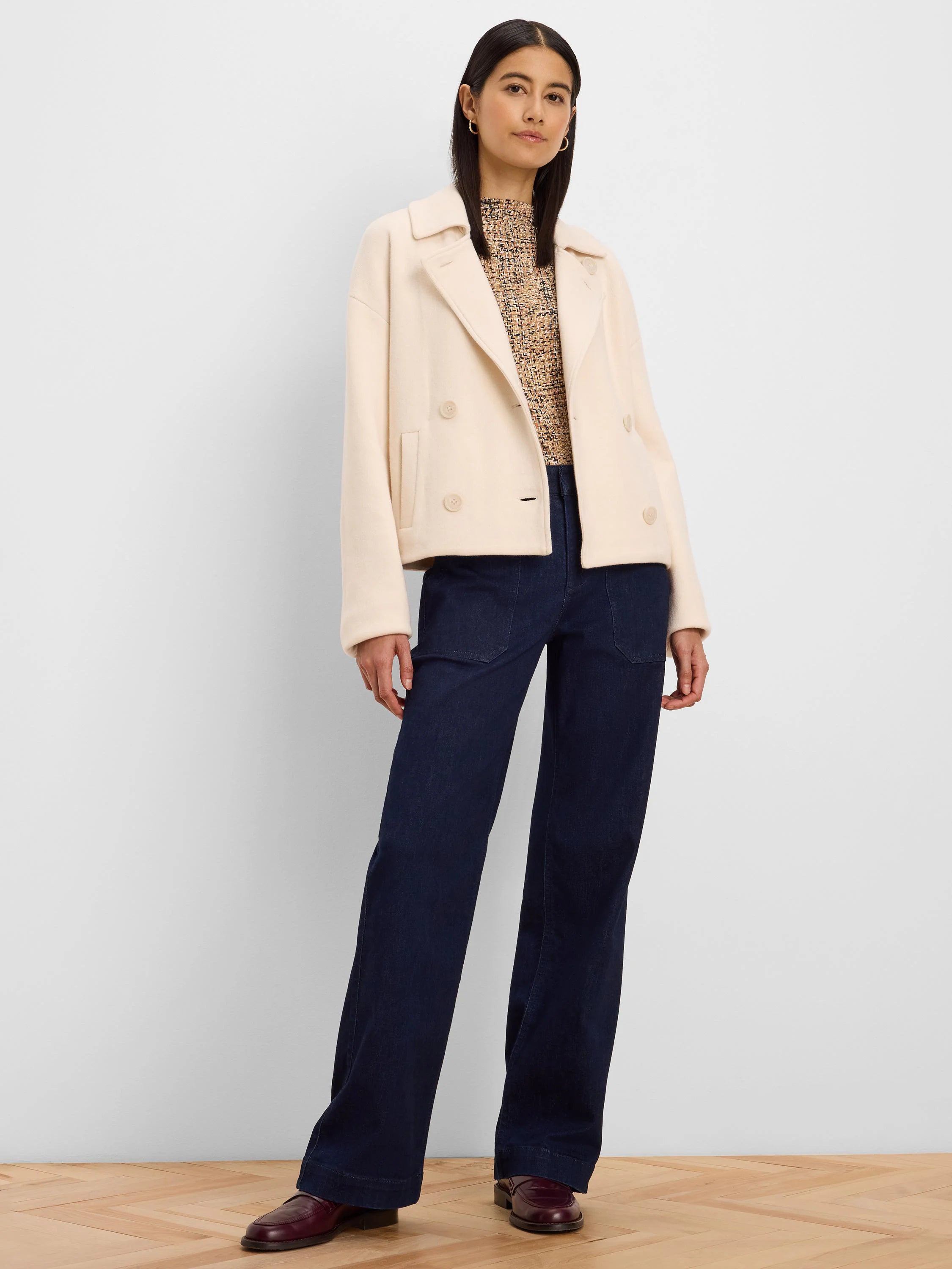 Cream knit jacket, cropped, double-breasted with notched lapels and visible buttons.