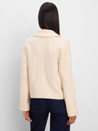 Cream knit jacket with a wide collar, relaxed fit, and long sleeves, shown from the back.