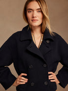 Dark navy double-breasted knit jacket with wide lapels and dark buttons.