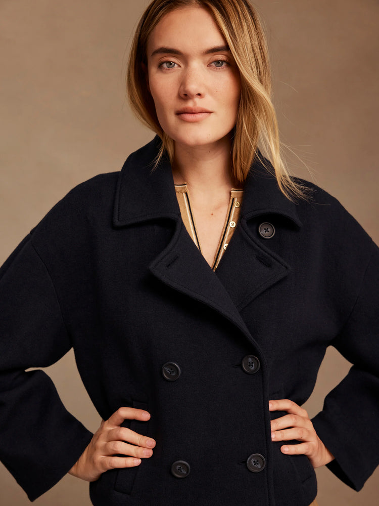 Dark navy double-breasted knit jacket with wide lapels and dark buttons.