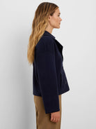 Navy blue knit jacket, cropped. Features a lapel collar, long sleeves, two front buttons, and patch pockets.
