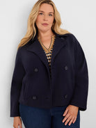 Navy knit jacket with double-breasted buttons, lapel collar, and front pockets. Cropped length.