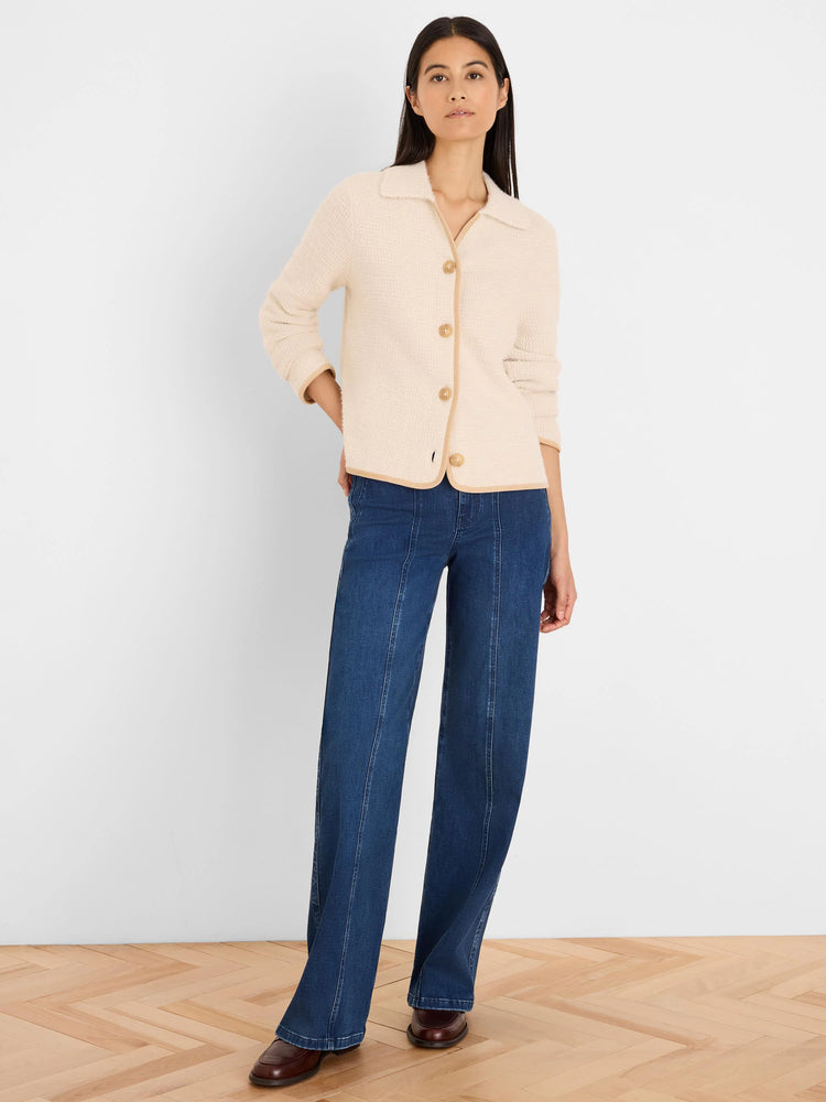 Cream cord knit jacket with tan trim on collar, button placket, and hem.