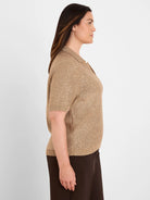 Champagne gold knit polo sweater with short sleeves and a V-neck, featuring scattered small silver sequins.
