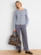 Light blue flecked shaker cardigan with cable knit texture and brown buttons.