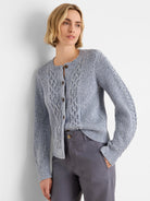 Light blue-grey flecked shaker knit cardigan with cable knit details and brown button-front closure.