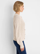 Cream flecked shaker cardigan with cable knit sleeves and dark brown buttons.
