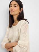 Cream sweater featuring a mix of open-knit, diamond, and ribbed stitch patterns.