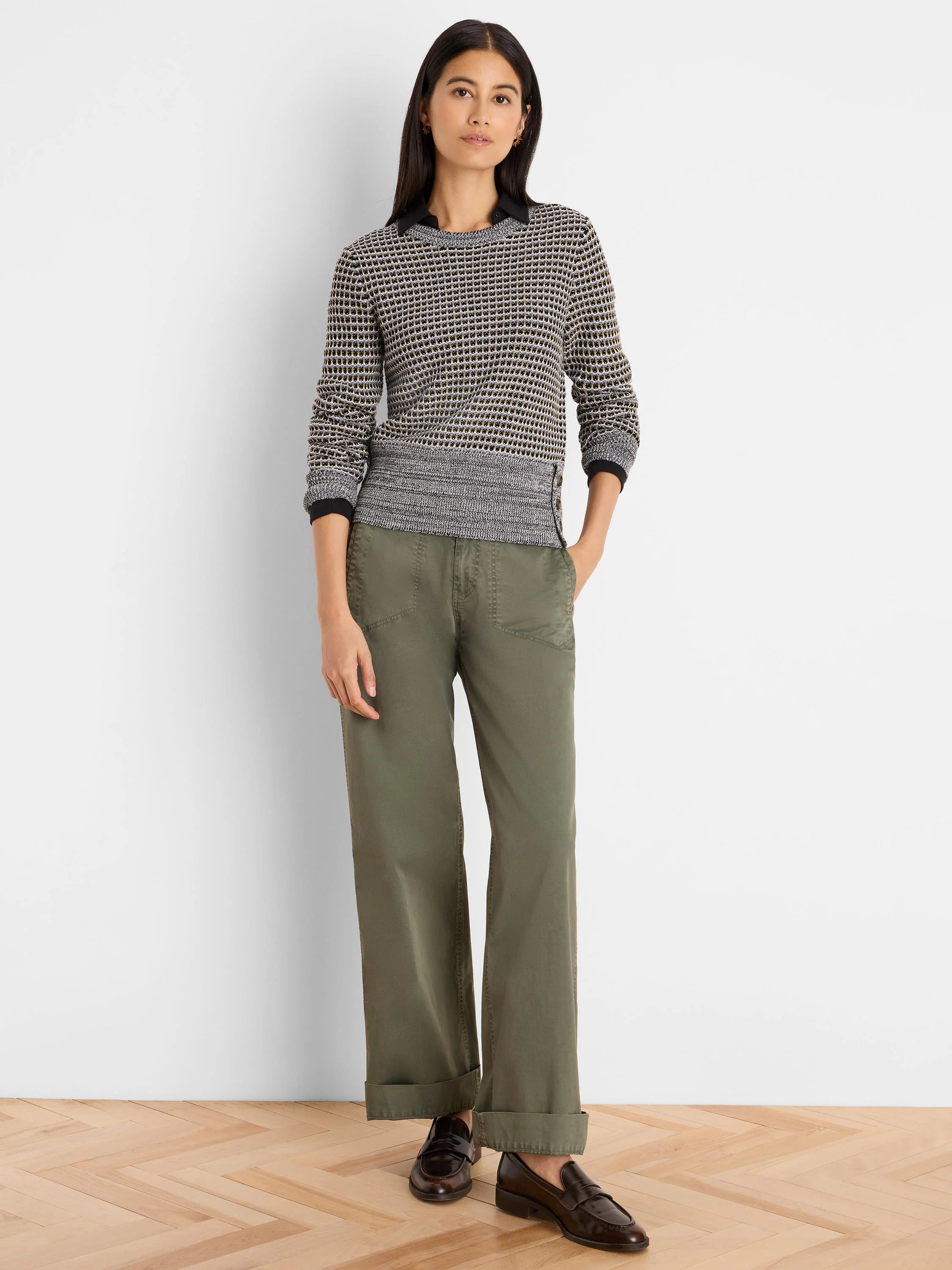 Marled knit sweater in grey, black, and tan pattern. Features ribbed cuffs, hem with decorative side buttons.