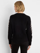 Black textured knit sweater with light criss-cross pattern on sleeves.