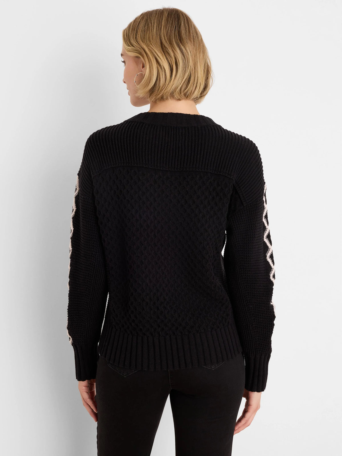 Black textured knit sweater with light criss-cross pattern on sleeves.