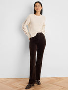 Cream cable knit sweater with a prominent criss-cross pattern on the sleeves.