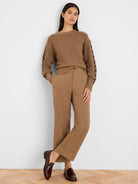 Tan knit sweater with a criss-cross textured body and darker brown criss-cross pattern on the sleeves.