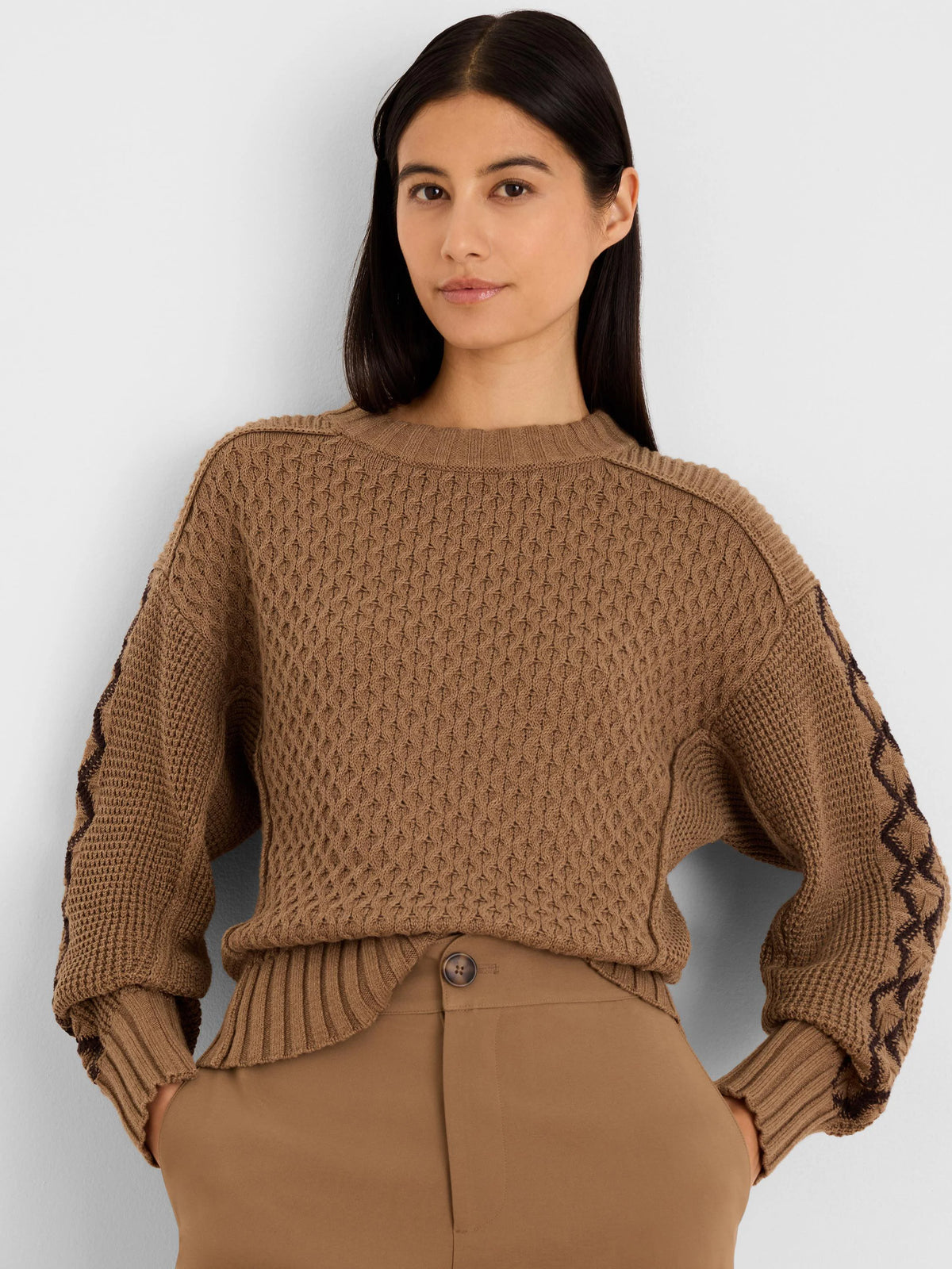 Brown textured sweater with dark brown criss-cross pattern on sleeves.