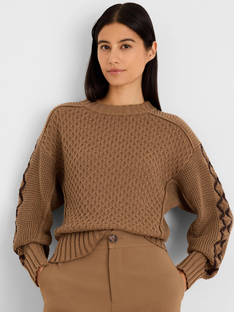 Brown textured sweater with dark brown criss-cross pattern on sleeves.
